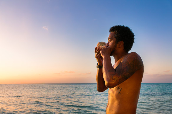Blowing a traditional conch shell in Fiji.