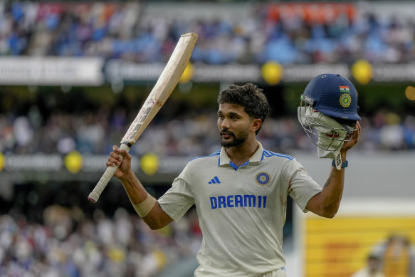 Nitish Kumar Reddy acknowledges the crowd as he walks off the field after bad light stopped play.