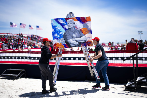 Masculinity pitch: Workers move a portrait of former president Donald Trump by the artist Scott LoBaido at a rally in Wildwood Beach, New Jersey.