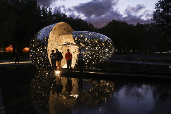 Visitors viewing Ouroboros at night.