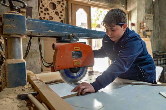 Mahmoud, 13, works as a carpenter. With three years’ experience, he now manages the electric saw.
