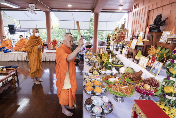 Monks at a table of offerings ahead of a traditional ceremony.