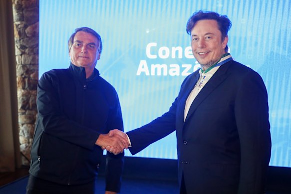 Brazil’s President Jair Bolsonaro, left, and Elon Musk shake hands during a meeting in Porto Feliz, Brazil.