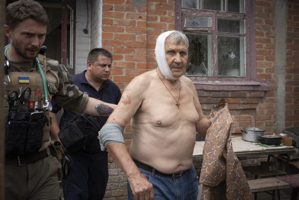 A paramedic helps a man wounded by Russian shelling to leave his house in Slovyansk, Donetsk region, Ukraine, on June 30.