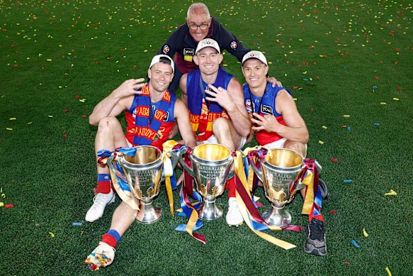 Lions coach and co-captains (from left) Josh Dunkley, Harris Andrews and Hugh McCluggage with the 2024, 2025 and 2026 premiership cups.