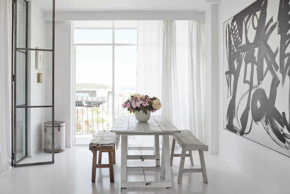 The dual-purpose trestle table sits in front of a Dick Watkins artwork. 