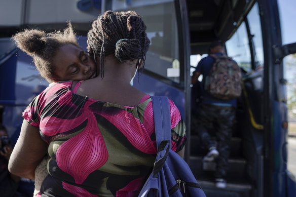 Çoğu Haiti'den gelen bir grup göçmenin sığınma talebiyle Del Rio, Teksas'ta ABD-Meksika sınırını geçtikten sonra serbest bırakılmasından birkaç dakika sonra San Antonio'ya giden bir otobüse binmeye hazırlanırken bir kadının omzunda uyuyan bir çocuk , eylülde.