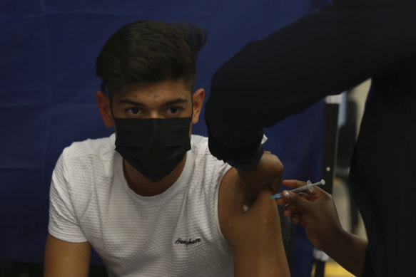 A teenager receives their COVID-19 vaccine. 