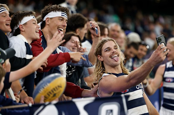 Smith takes a selfie with some headbanded fans.