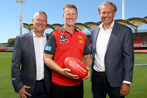 Damien Hardwick with Gold Coast chief executive Mark Evans and chairman Bob East.