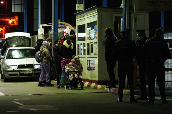 People speak to Romanian border officials in Sighetu Marmatiei after crossing from Ukraine on Thursday night.