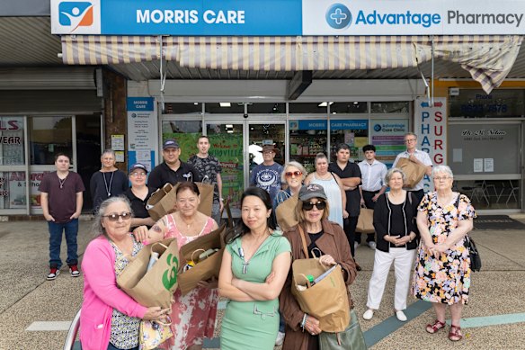 Veronica Nou (centre) with members of the St Marys community preparing Christmas hampers for the food bank. They have rallied behind her amid anti-Asian attacks near her business. 