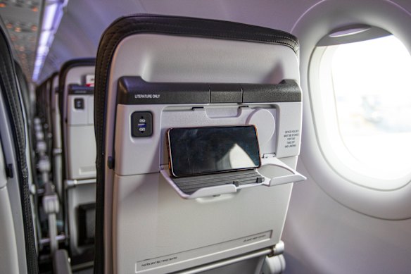 Flip-down smartphone and tablet cradles replace seatback entertainment screens.