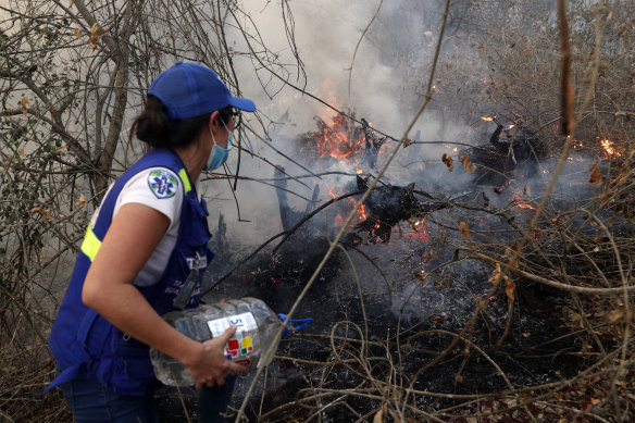 A volunteer works to put out a fire in Aguas Calientes on the outskirts of Robore, Bolivia, on Saturday.
