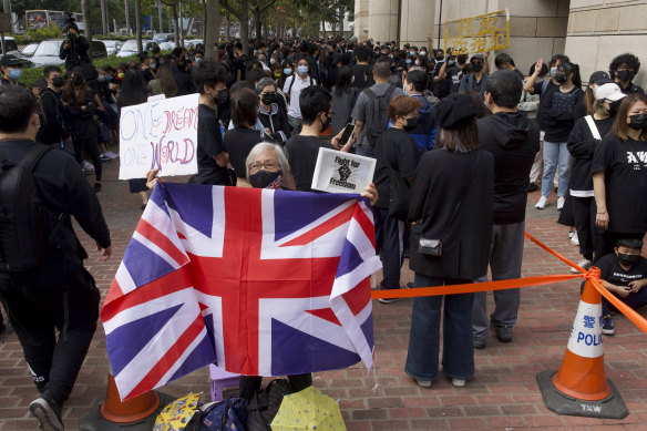 A woman holds a British flag as supporters queue up outside a court to try to get in for a hearing in Hong Kong on Monday.