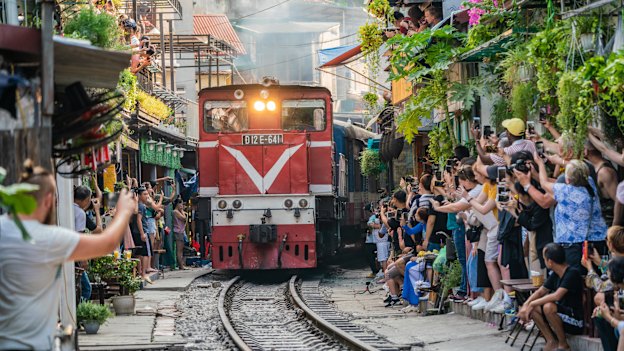 Several times daily a full-size train slowly makes its way through Hanoi’s famous (or infamous) tourist train street.
