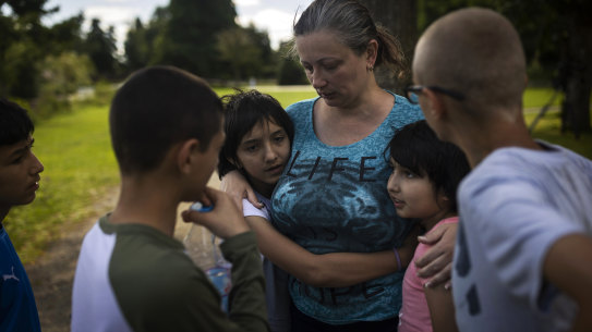 Olga Lopatkina embraces her adopted children in a park in Loue, western France in July.