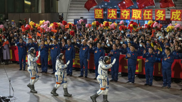 Chinese astronauts wave to wellwishers as they take part in a pre-launch departure ceremony on October 15 at the Jiuquan Satellite Launch Centre in Jiuquan, China. 
