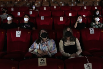 Moviegoers at a theatre in Bangkok, Thailand, where people are increasingly declining to stand when the royal anthem is being played.  