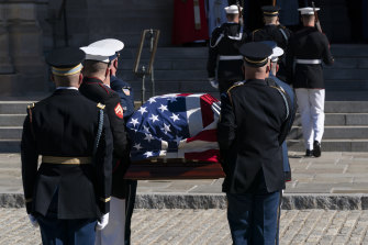 Colin Powellâ€™s flag-draped casket is carried into the Washington National Cathedral.