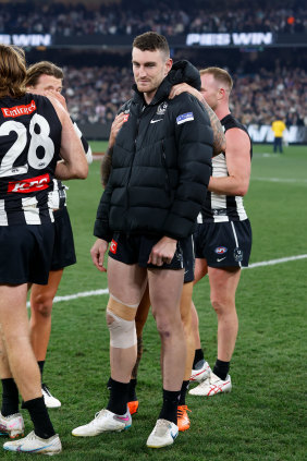 Dan McStay is consoled by teammates after Collingwood’s preliminary final victory.
