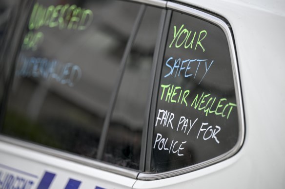 A message pushing for better pay written on a police vehicle in 2024.