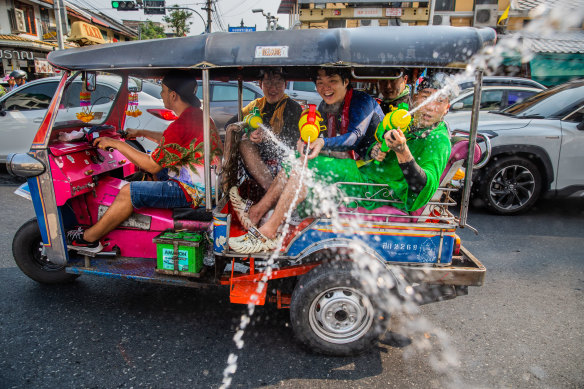 Tourists spray water guns out of a tuk tuk during the Songkran festival in Bangkok.