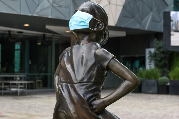 The Fearless Girl Statue in Federation Square dons a face mask.