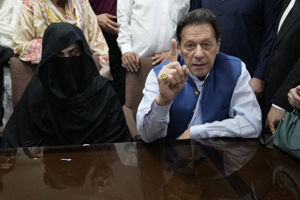 akistan’s former Prime Minister Imran Khan, right, and Bushra Bibi,his wife, talk to the media in July 2023.