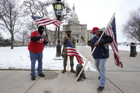 Protesters stand peacefully outside the state capitol in Lansing, Michigan during the inauguration. 
