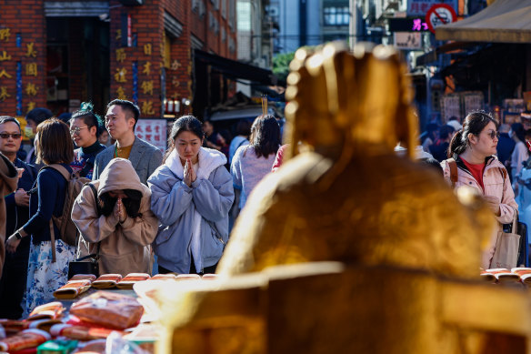 Worshippers pray at the Taipei Xiahai Chenghuang Temple after voting in Saturday’s election.  