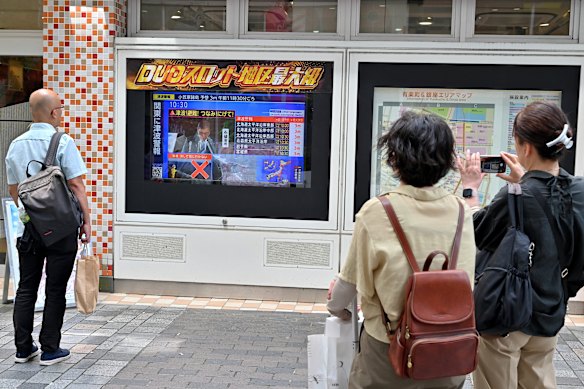 A tsunami warning for parts of coastal Japan is broadcast in Tokyo on July 30.  