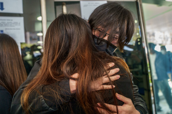 Mike Lam, founder of AbouThai, hugs his wife outside Ma On Shan police station in Hong Kong. He was among 47 opposition activists detained on Sunday.
