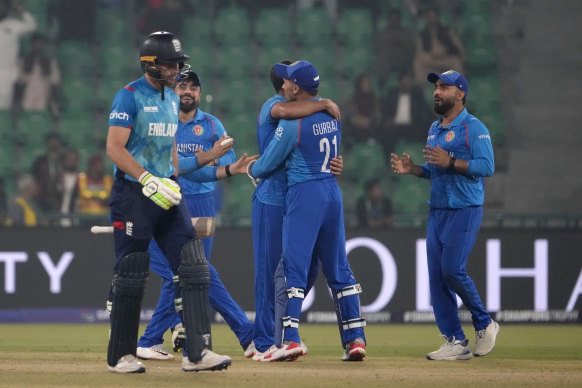 England’s Jos Buttler, left, walks off the field as Afghanistan players celebrates after his dismissal during their clash on Wednesday.