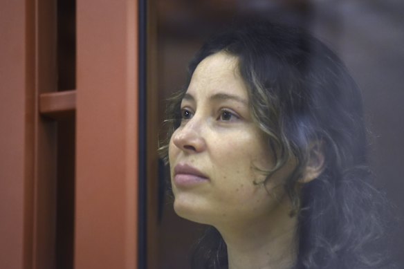 Ksenia Karelina sits in a glass cage in a courtroom in Yekaterinburg, Russia.