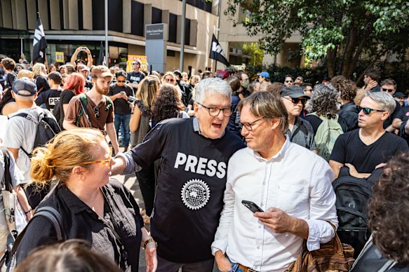 Late Night Live host David Marr, centre left, speaks to Four Corners reporter Angus Grigg during a rally by staff outside the public broadcaster’s headquarters in Sydney.