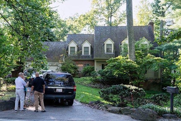 Police outside John Bolton’s house as FBI agents search the premises.