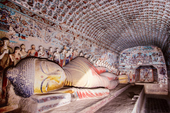 A gold reclining buddha statue at the Mogao Caves in the desert near Dunhuang, China.