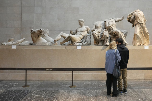 Visitors look at sculptures that are part of the Parthenon Marbles at the British Museum in London.