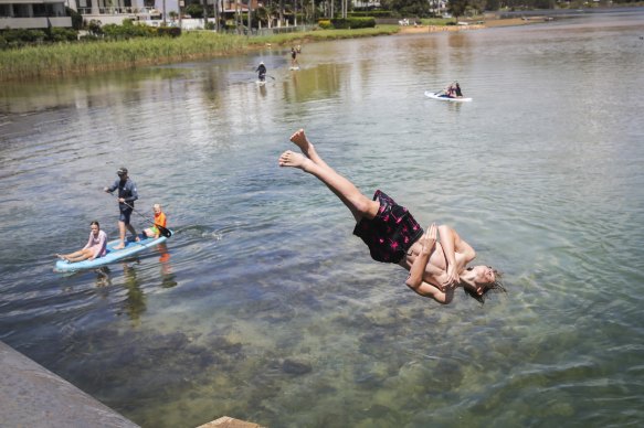 Swimmers enjoy the warm weather at Narrabeen Lakes on Sydney’s northern beaches on Sunday.