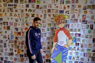 YouTube artist Sultan Sketches with a cardboard cut-out of his avatar, and a wall of fan art inspired by his videos.