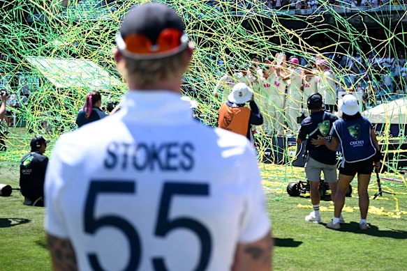 Ben Stokes looks on as Australia celebrate.
