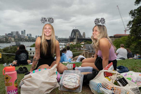 Canadian Madi Cook (left) and Megan Elias, from Wales, packed a cake for the 14-hour wait for the midnight fireworks.