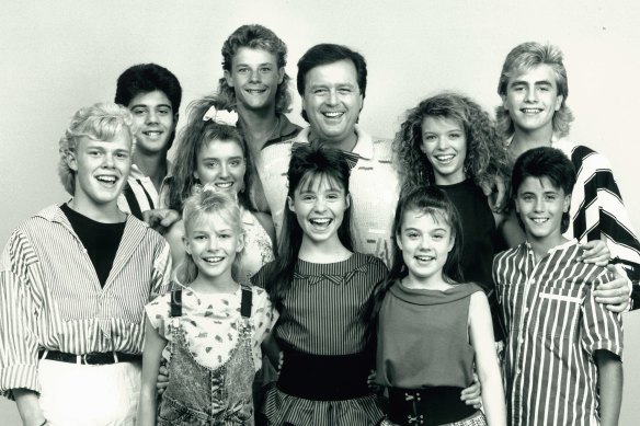 Front row (left to right): Greg Poynton, Rikki Arnott, Juanita Coco (dec), Courtney Compagnino, Joey Dee. Middle row: Vince Del Tito, Dannii Minogue, Johnny Young, Natalie Miller, Mark Stevens. Back: Beven Addinsall. 