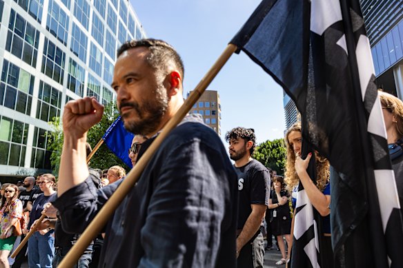 7.30 reporter Jason Om holds a union flag at a rally in Sydney.