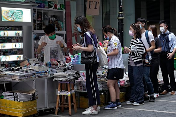 People queue to buy copies of Apple Daily in Hong Kong on Tuesday morning. 