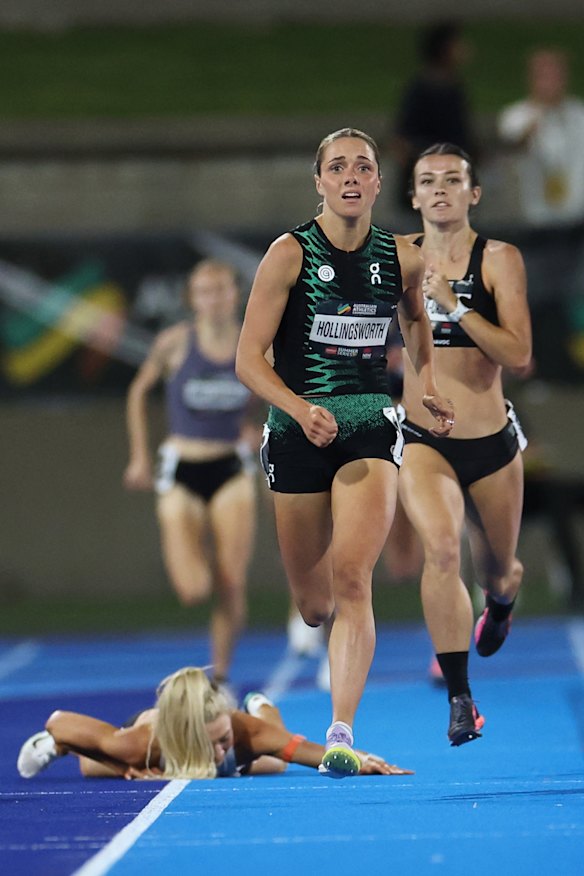 Jess Hull sprawled on the ground as Claudia Hollingsworth sprints to the line.