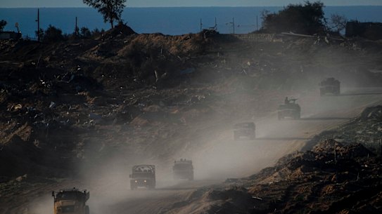 A convoy of Israeli troops moves in the Gaza Strip as seen from southern Israel on Thursday.