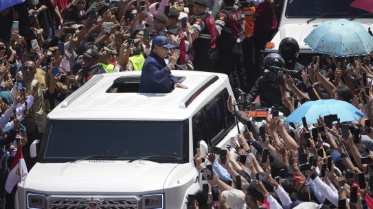 Subianto, center, greets supporters after being sworn in as the country’s eighth president in Jakarta.