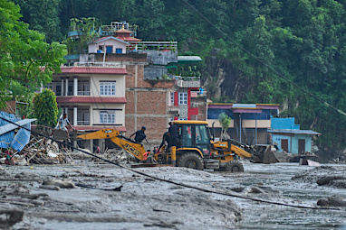 Rescuers use earthmovers to reach submerged houses after flash flooding along the Trishuli River in Nepal’s Nuwakot district.